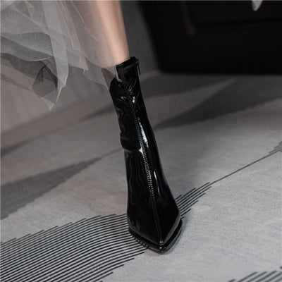 Black glossy high-heeled boot on a neutral background
