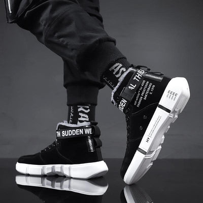 Black high-top sneakers with white soles on a reflective surface and dark background