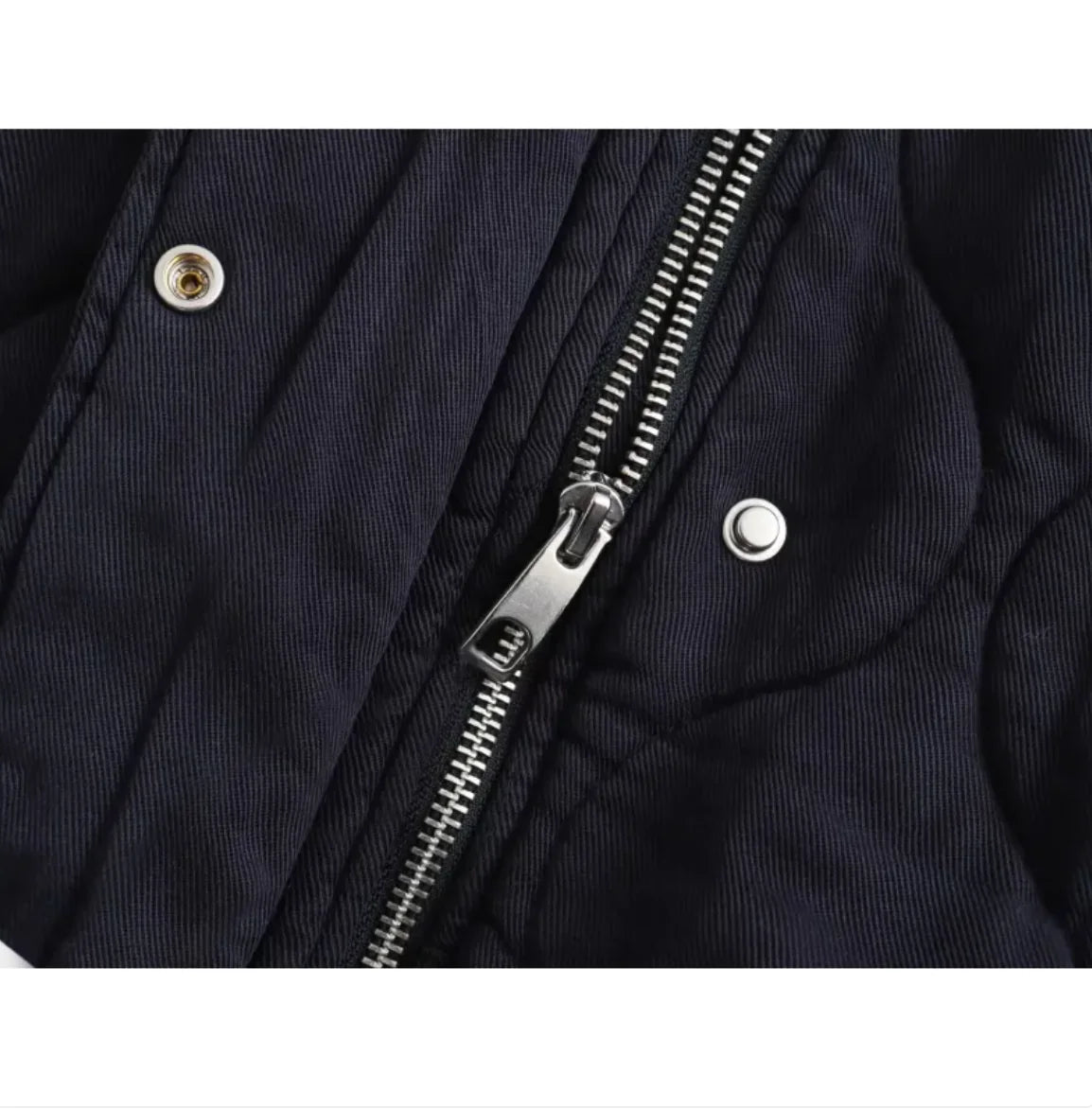 Close-up of a navy blue jacket with a silver zipper and buttons.