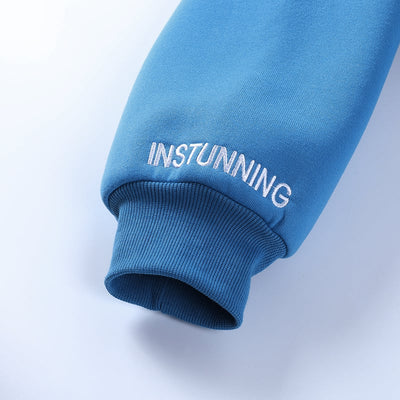 Blue sweatshirt sleeve with 'INSTUNNING' text on a light gray background
