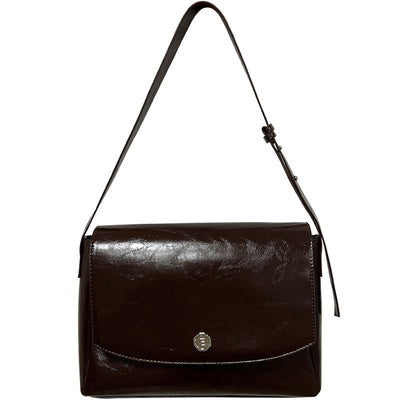 Brown leather handbag with a strap on a white background