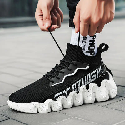 Person tying a black and white sock sneaker on a pavement background