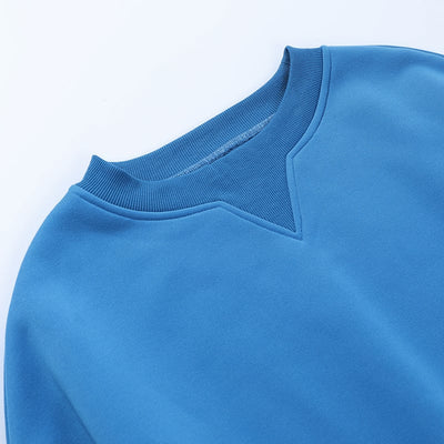 Close-up of a blue sweater with a plain background