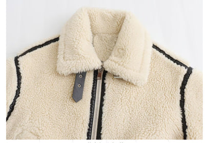Close-up of a cream-colored fleece jacket with black trim on a white background