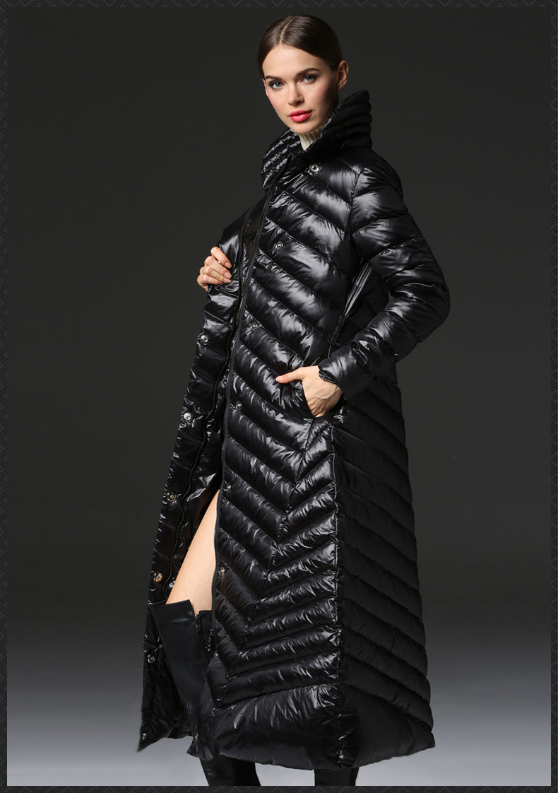 Woman wearing a long black puffer coat against a dark background