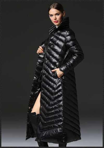 Woman wearing a long black puffer coat against a dark background
