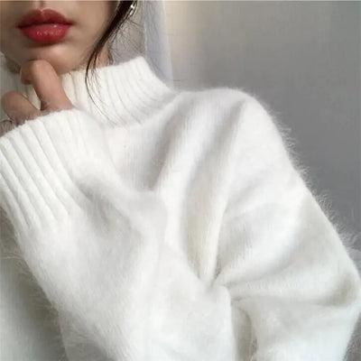 Close-up of a person wearing a white sweater with a blurred background