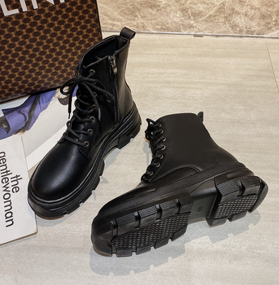 Black boots with thick soles on a light surface