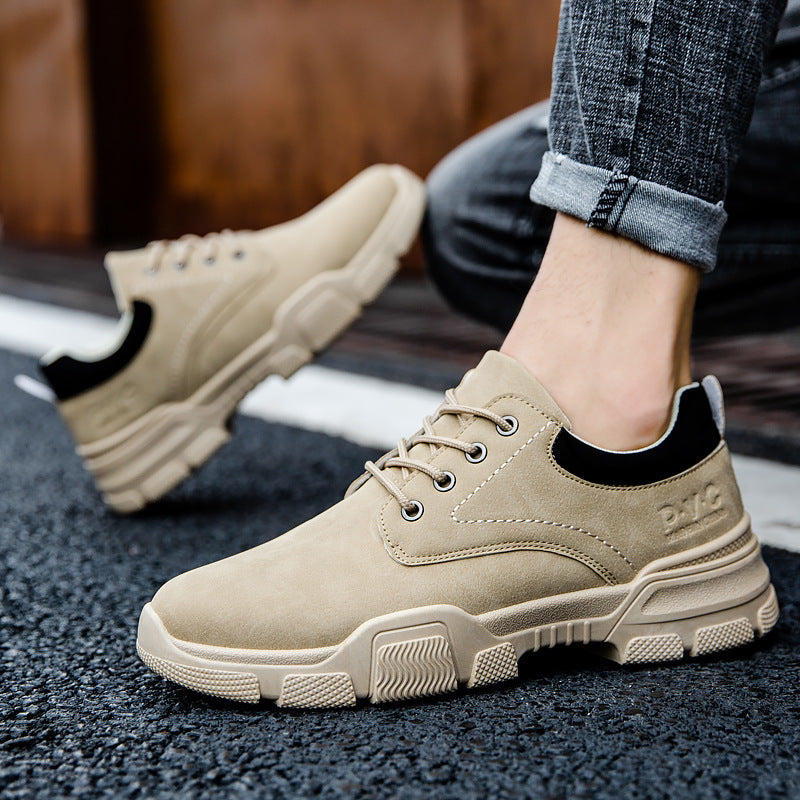 Beige sneakers worn with rolled-up jeans on a dark surface