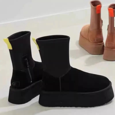 Black ankle boots with yellow accents on a white background