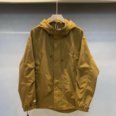 Yellow raincoat on a hanger against a plain background