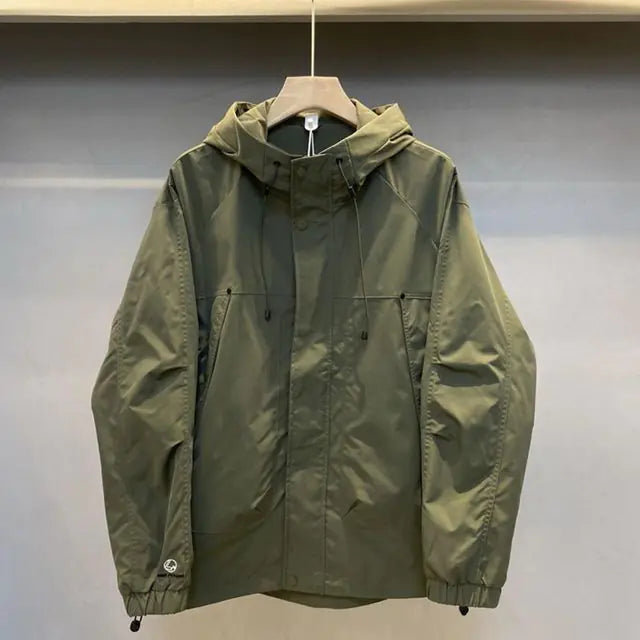 Green raincoat on a hanger against a plain background