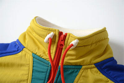 Close-up of a colorful jacket with a red zipper on a white background
