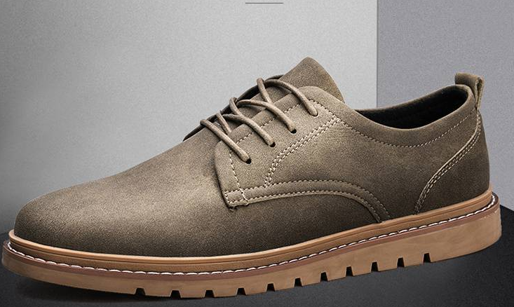 Brown suede shoe with a brown sole on a gray background