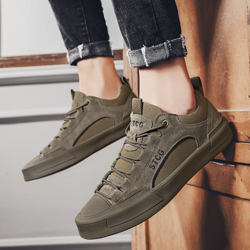 Green sneakers with 'STCG' branding worn by a person on a wooden floor.