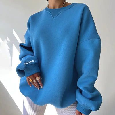 Blue sweatshirt worn by a person with a neutral background