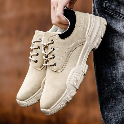 Beige shoes held by a person against a blurred background