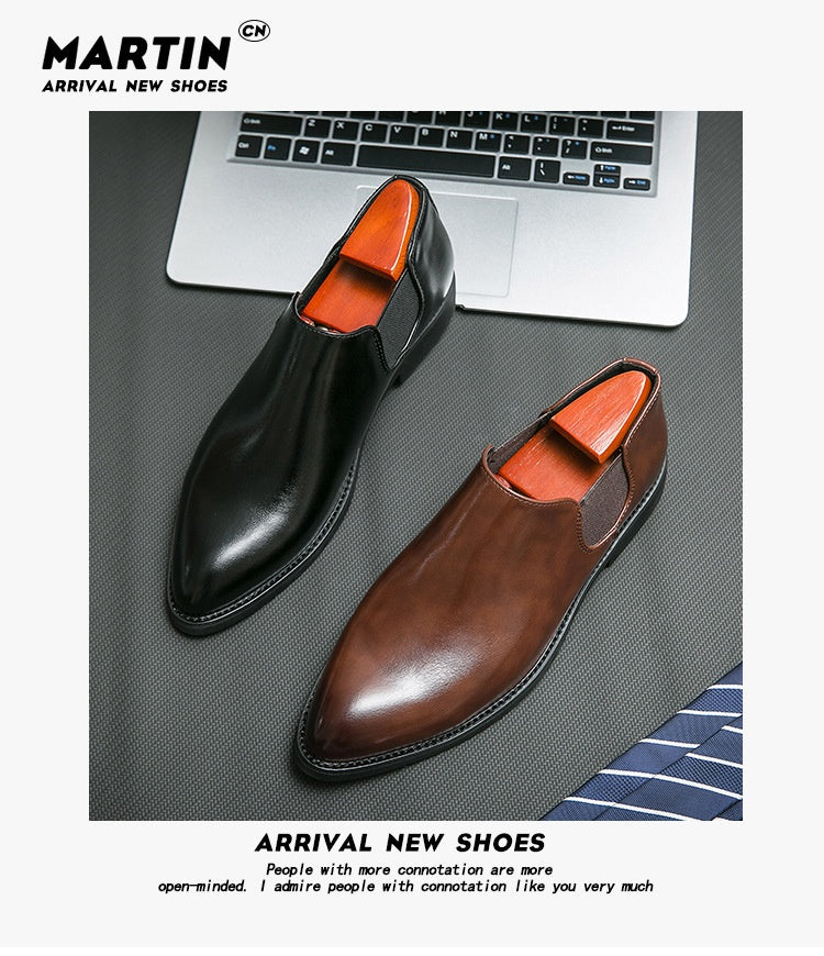 Black and brown shoes on a desk with a laptop