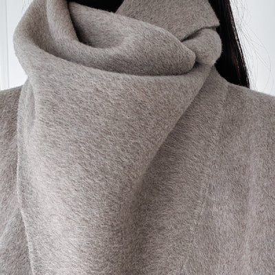 Close-up of a gray scarf wrapped around a person's neck.