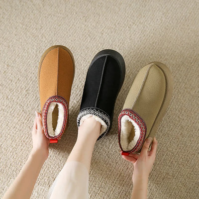 Three pairs of slippers held by a person on a beige carpet.