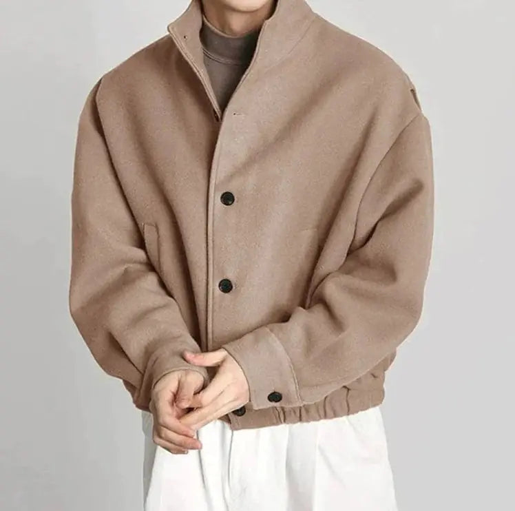Beige jacket worn by a person on a plain background