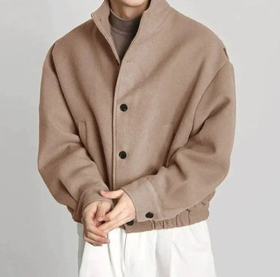 Beige jacket worn by a person on a plain background
