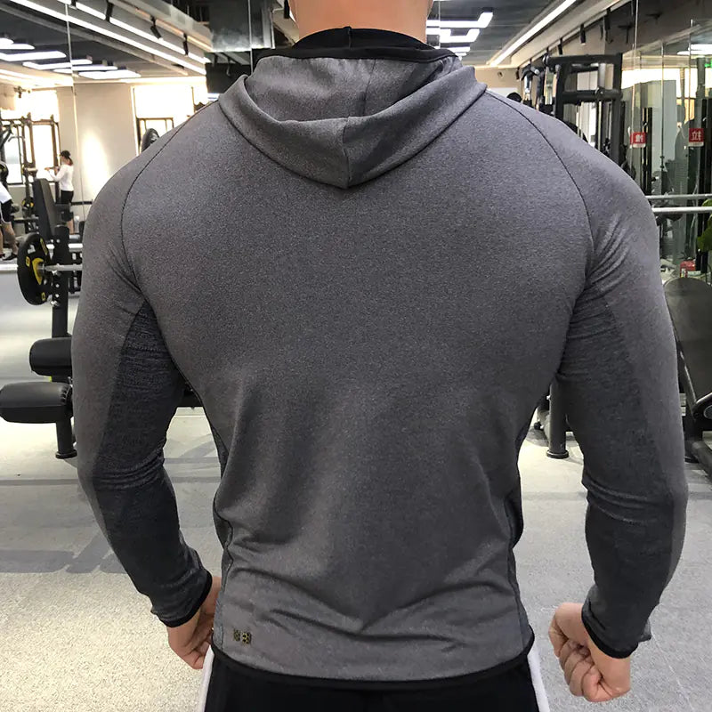Person wearing a gray hoodie in a gym setting