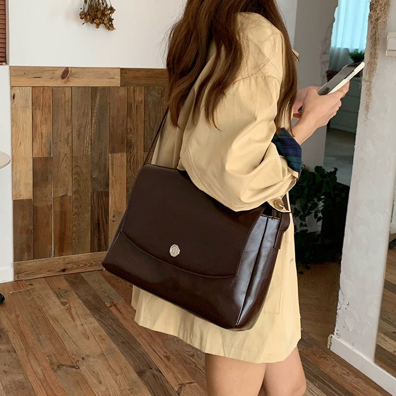 Woman holding a brown leather handbag indoors