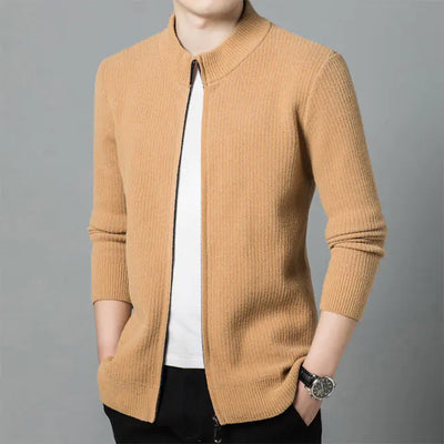 Person wearing a mustard yellow sweater over a white shirt on a gray background