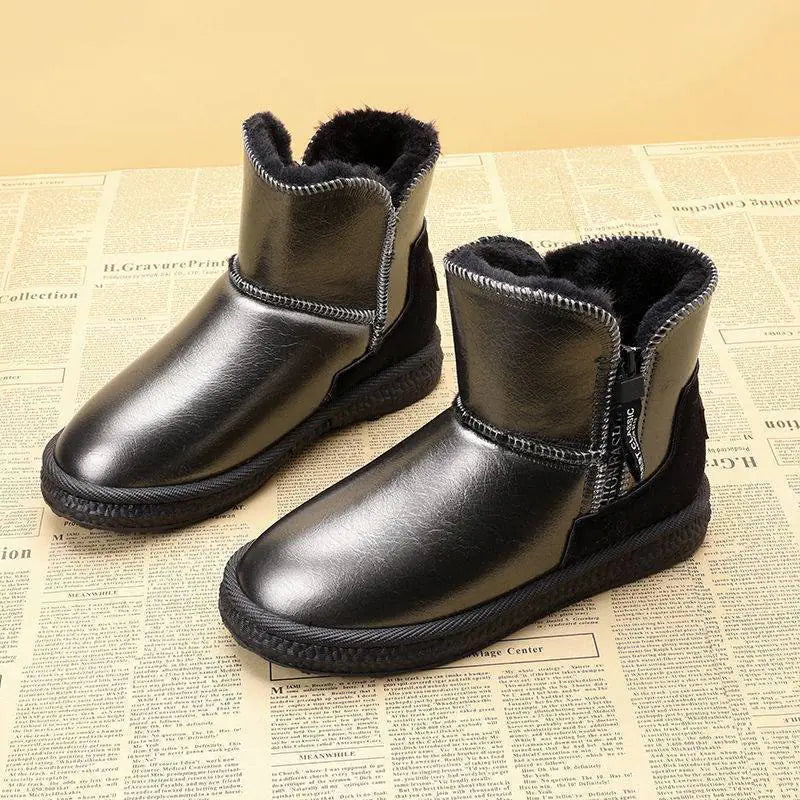 Pair of black leather boots with fur lining on a newspaper background