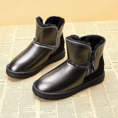 Pair of black leather boots with fur lining on a newspaper background