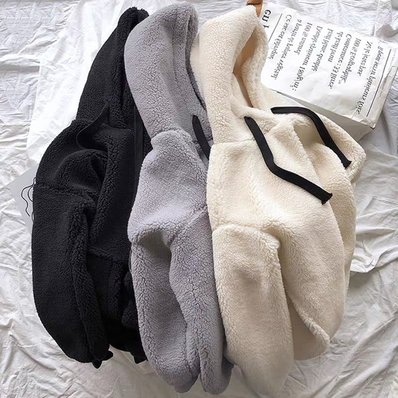 Three pairs of fleece-lined socks in black, gray, and white on a white surface.