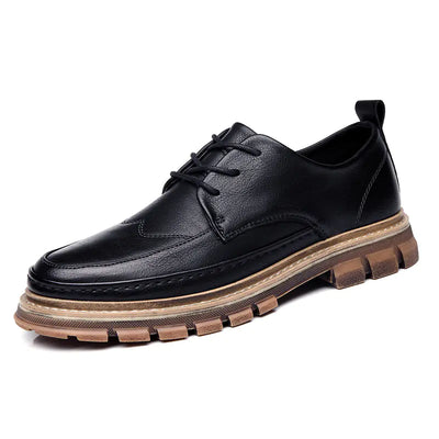 Black leather shoe with a brown sole on a white background