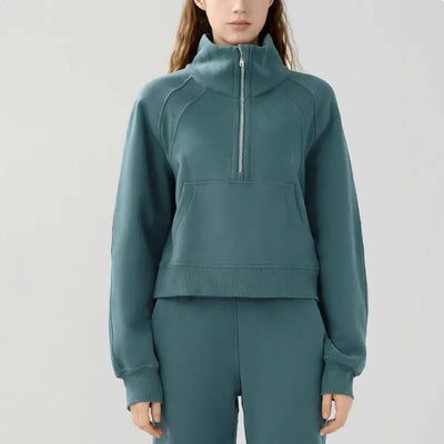 Teal tracksuit worn by a person on a light gray background