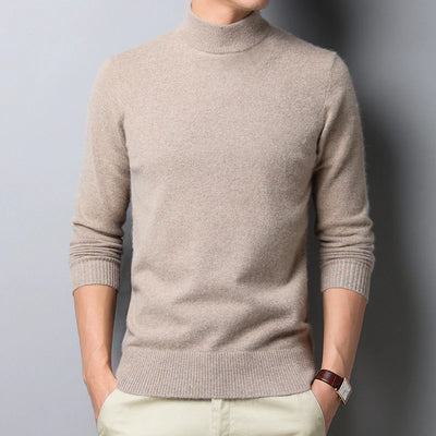 Person wearing a beige turtleneck sweater against a gray background