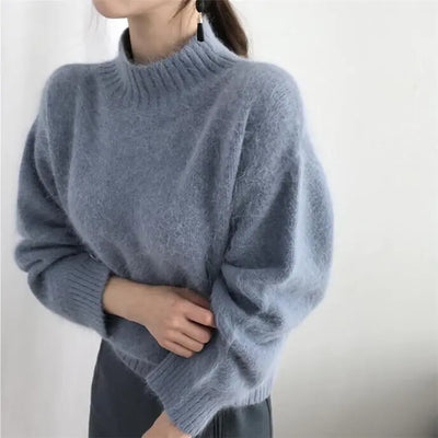 Person wearing a light blue sweater against a white background