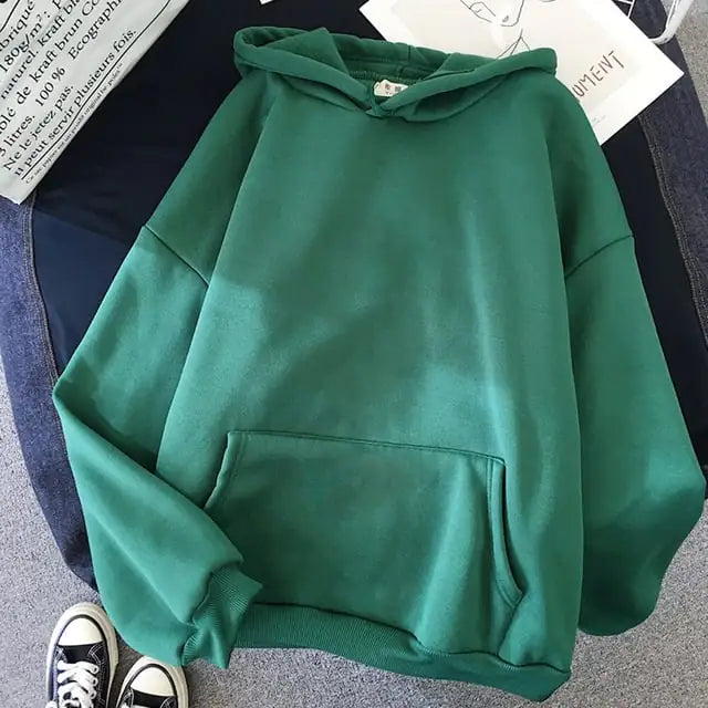Green hoodie on a surface with a magazine underneath