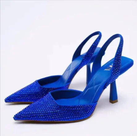 Blue studded high-heeled shoes on a white background