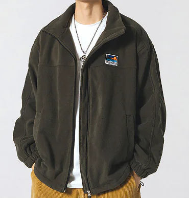 Person wearing a dark green jacket with a small logo