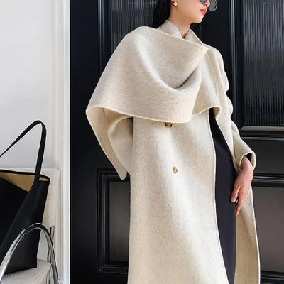 Person wearing a beige coat with a black background