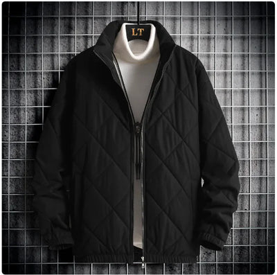 Black quilted jacket with a white shirt underneath on a textured gray background