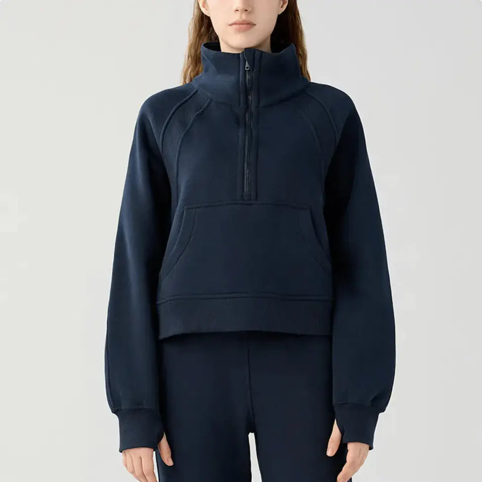 Person wearing a navy blue half-zip sweatshirt on a light gray background