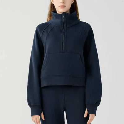 Person wearing a navy blue half-zip sweatshirt on a light gray background