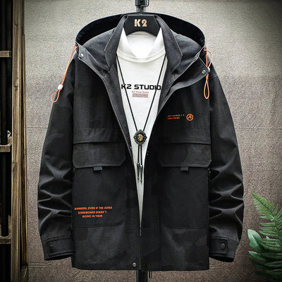 Black jacket with orange accents on a hanger against a gray wall.