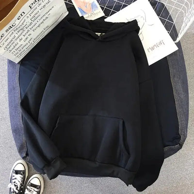 Black hoodie on a gray surface with a magazine underneath