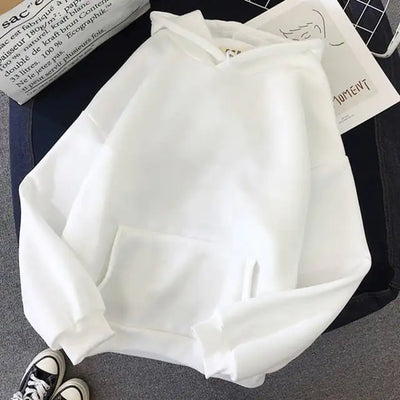White hoodie on a dark surface with text and clothing items in the background