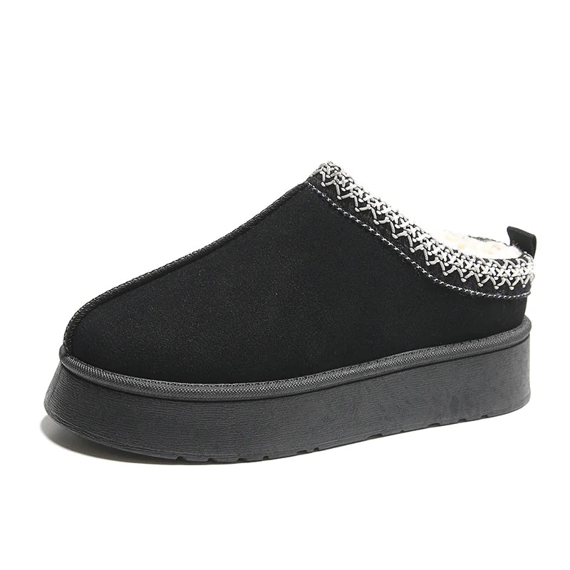 Black slipper with decorative trim on a white background