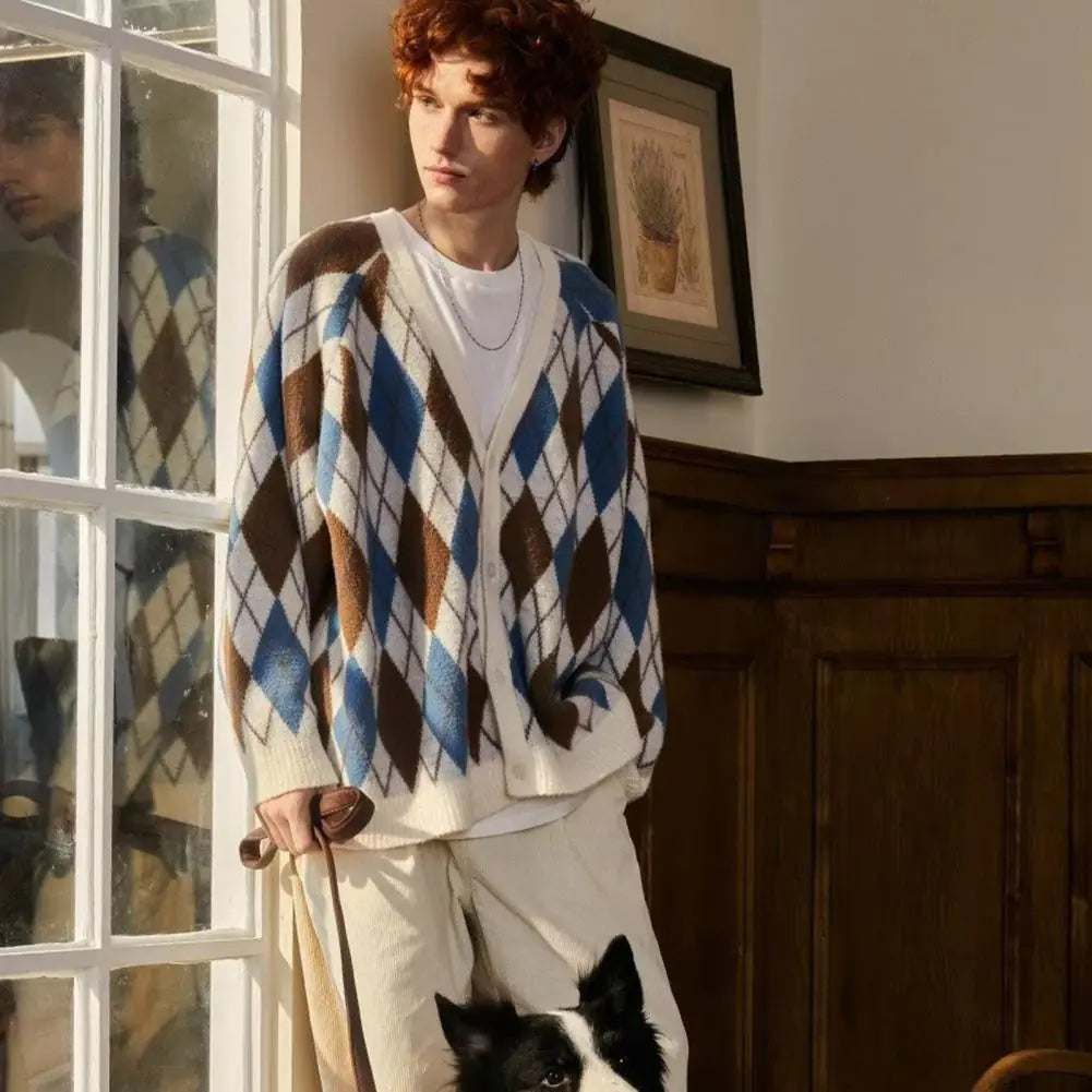 Person wearing a patterned sweater standing indoors with a dog by their side.