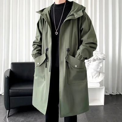 Person wearing a green coat in an indoor setting with a black chair and white sculpture.