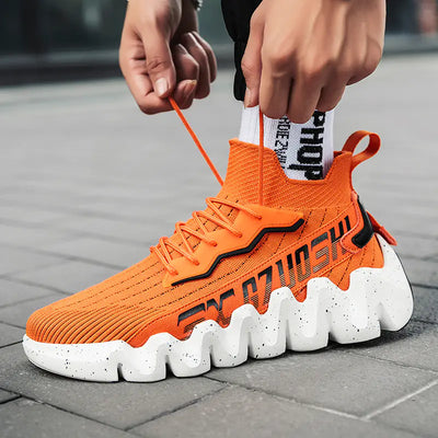 Orange sock sneaker with white sole being worn on a pavement background